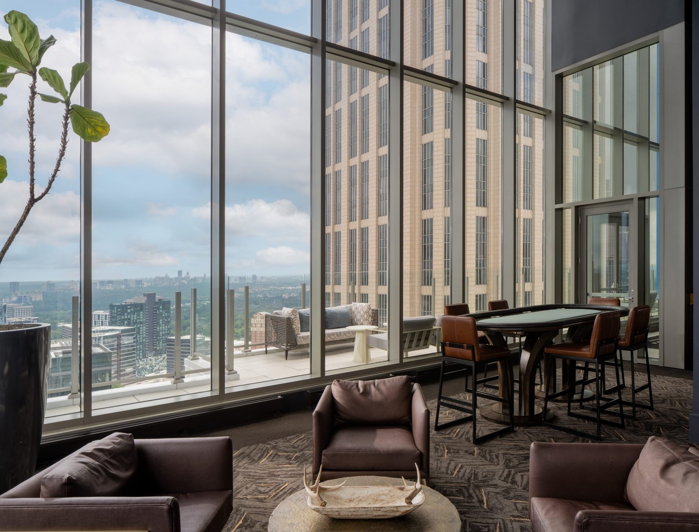 Indoor common area with floor to ceiling windows in The Hue Midtown apartments